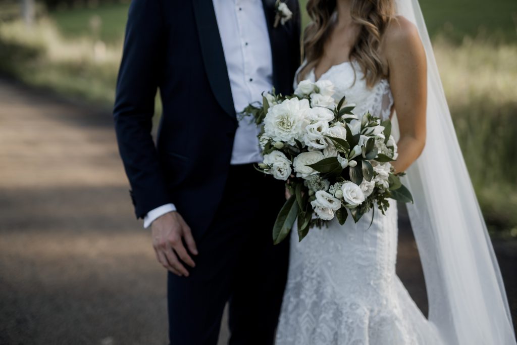 Modern white wedding bouquet featuring dahlias and lush greenery